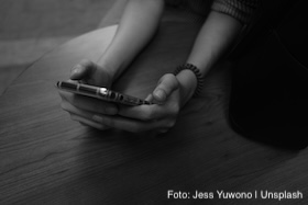Zwei Hände halten ein Smartphone fest.